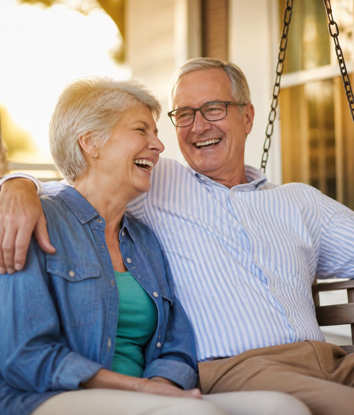 A happy senior couple sitting together outdoors